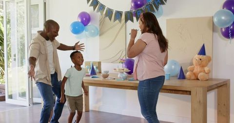 Joyful Family Celebrating Birthday at Home with Laughter and Dance
