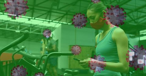 Masked Woman Using Smartphone at Gym Amid COVID-19 Pandemic