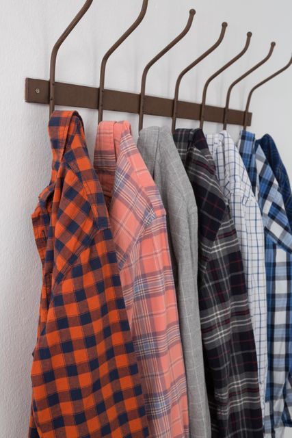 Close-up of various shirts hanging on hook against white wall