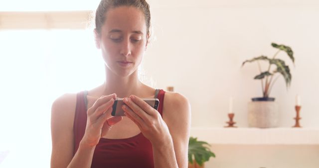 Young Woman Using Smartphone at Home with Natural Light - Download Free Stock Images Pikwizard.com