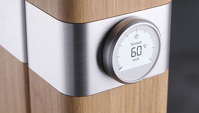 Minimalist smart thermostat on oak column with brushed steel band and circular lcd gauge