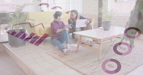 Businesswomen Collaborating on Reports with Data Interface Overlay