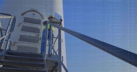 Construction worker analyzing data on tower platform outdoors