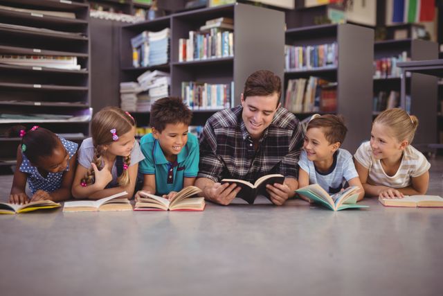 Teacher and a group of diverse children lying on the floor, reading books together in a library. Ideal for use in educational materials, school brochures, literacy campaigns, and articles promoting reading and learning among young students.