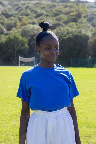 Confident Teenage Girl on Soccer Field in Bright Sportswear