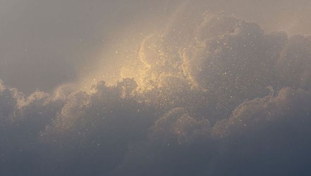 Glowing golden cumulus cloudscape casting sparkling twilight halo