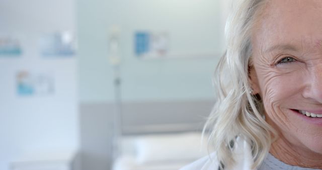 Senior woman with grey hair, smiling gently in hospital room. Ideal for healthcare, aging, wellness, and patient care themes in medical advertisements, caregiving brochures, senior lifestyle magazines, and hospital websites.