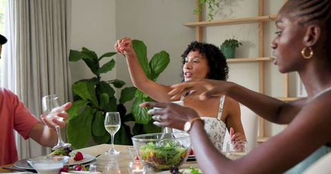 Friends Sharing Meal Together in Cozy Home Environment