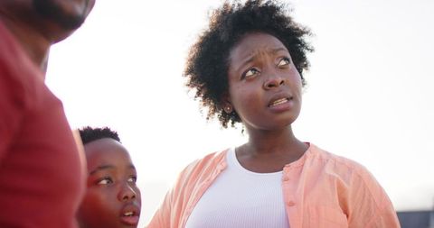 African american mother and son looking up outdoors in bright daylight, casual portrait