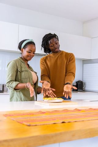 African american couple presenting baked tart on kitchen island modern home cooking