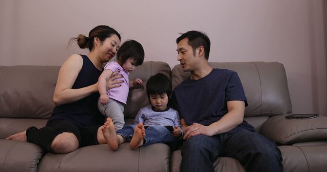 Happy Family Sitting on Couch with Young Children - Download Free Stock Images Pikwizard.com