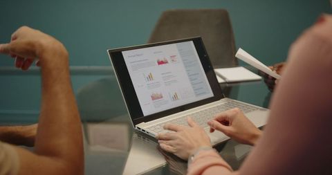 Colleagues collaborating on financial report in office