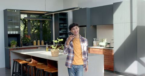 Man Engaging on Smartphone in Stylish Modern Kitchen