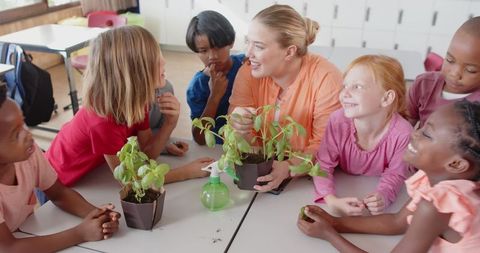 Diverse students learning about plants with educator in classroom
