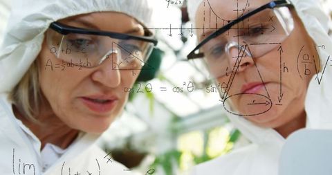 Scientists analyzing data on transparent screen in laboratory