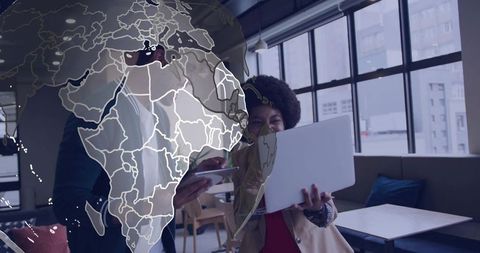Global collaboration in modern coworking space: professionals using laptop and tablet