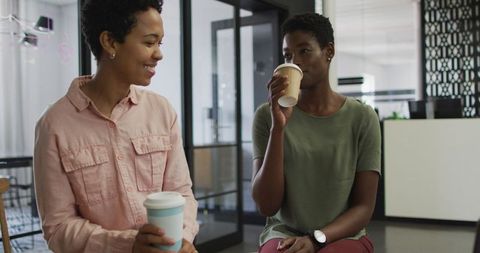 Diverse Businesswomen Enjoying Coffee in Modern Office Environment