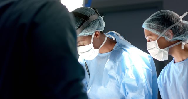 Diverse surgeons with face masks during surgery in operating room - Download Free Stock Photos Pikwizard.com