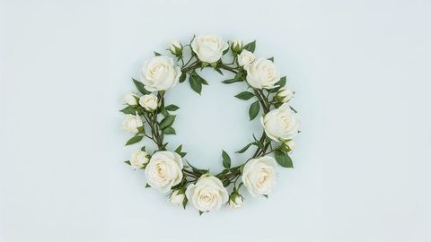 Elegant white rose wreath with green leaves on blank background