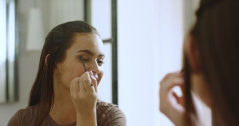 Woman Applying Eyeshadow at Home Near Mirror