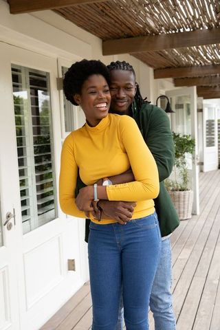 Smiling Couple Embracing on Sunlit Porch