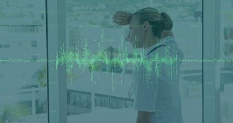 Doctor pondering urban city lifestyle through hospital window