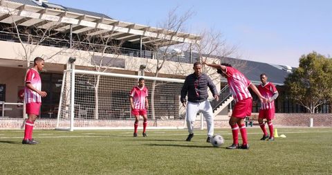 Coach Guiding Youth Soccer Team in Drills on School Field