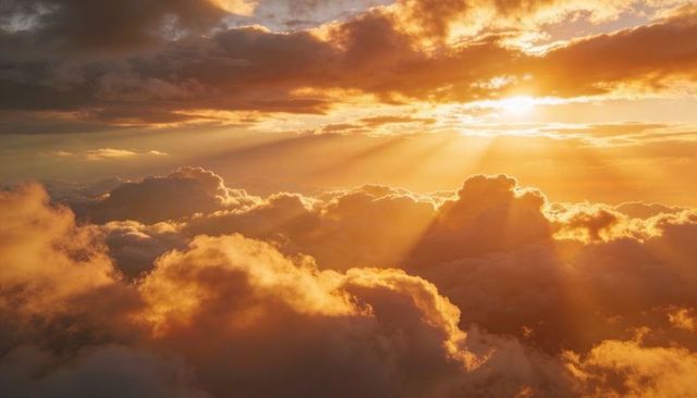 Sunlight streaming through golden cumulus clouds revealing crepuscular rays at sunrise