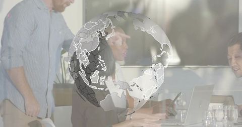 Collaborating business team working at boardroom table with laptop and transparent globe overlay