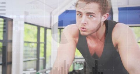 Pedaling spin bike: focused male athlete training with performance data overlay
