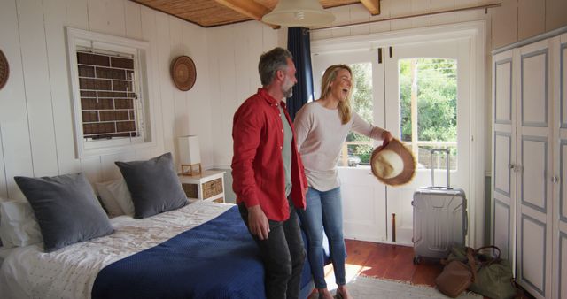 Couple Laughing and Enjoying Vacation in Cozy Bedroom Setting - Download Free Stock Images Pikwizard.com