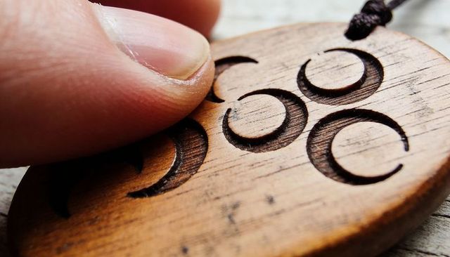 Finger pressing hand-carved wooden crescent pendant, rustic jewelry detail
