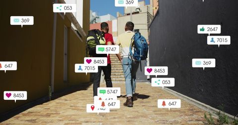 Friends engaging with social media walking down urban street