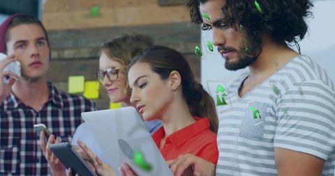 Young Professionals Collaborating with Digital Technology in Office