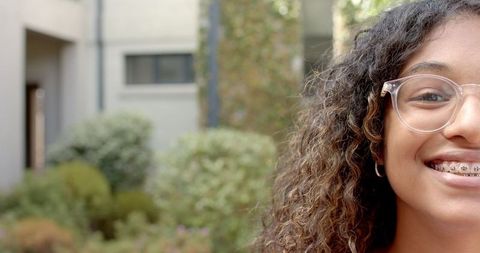 Smiling Teenager Outdoors in Braces with Lush Background