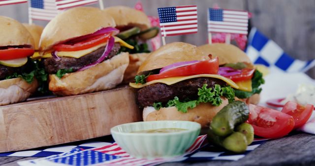 Mouth-watering American-style cheeseburgers topped with fresh onions, tomatoes, lettuce, and cheese, decorated with American flags. Ideal for summer BBQs, Fourth of July parties, picnics, and any celebration of American cuisine or national pride. Perfect for use in advertisements, food blogs, and event invitations.