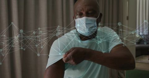 Senior black man pulling up sleeve for vaccination with digital health network overlay