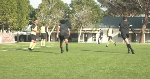 Teen soccer players competing intensely on green field