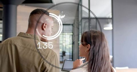 Coworkers Collaborating on Tablet with Futuristic HUD Overlay in Modern Workspace