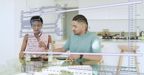 Couple eating while interacting with augmented reality display in modern kitchen lifestyle