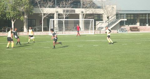 Youth Soccer Team Engaging in Strategic Play on Sunny Field