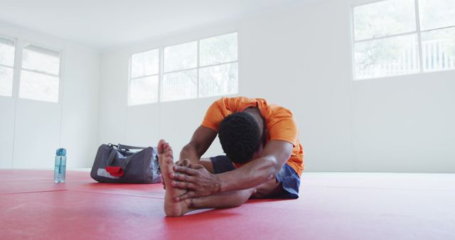 Man Stretching on Red Mat in Gym Room - Download Free Stock Images Pikwizard.com