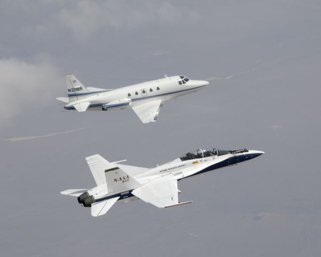 This image depicts a NASA F/A-18 jet in close formation following a Sabreliner jet during a flight test. The F/A-18 is testing autonomous software as part of the AARD program. This photo is ideal for use in articles or presentations on aerospace technology, autonomous aircraft testing, flight engineering, or NASA research missions.