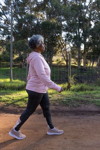 Senior Woman Walking in Park Promoting Healthy Lifestyle