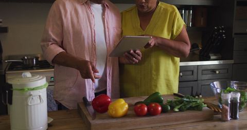 Senior Couple Following Online Recipe in Kitchen