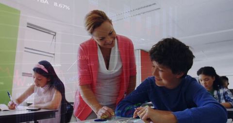 Female Teacher Assisting Student in Busy Classroom