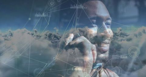 Smiling african american man on smartphone amidst digital cloud