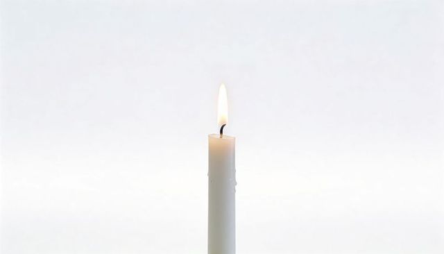 Minimalist burning white taper candle with warm flame and wax drips on neutral gradient