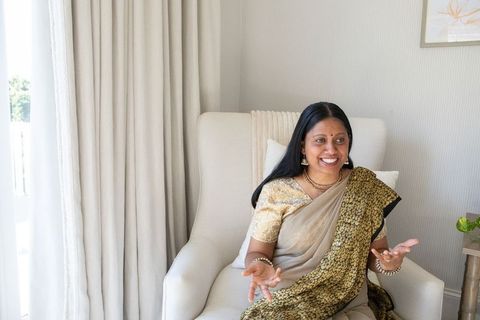 Senior indian woman in sari relaxing at home in contemporary armchair