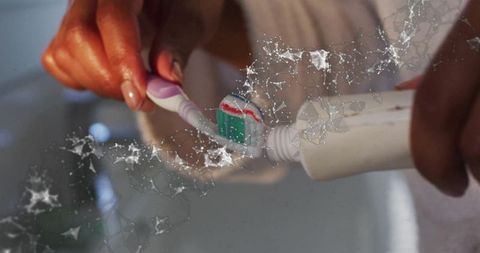 Applying toothpaste to toothbrush in daily dental care routine